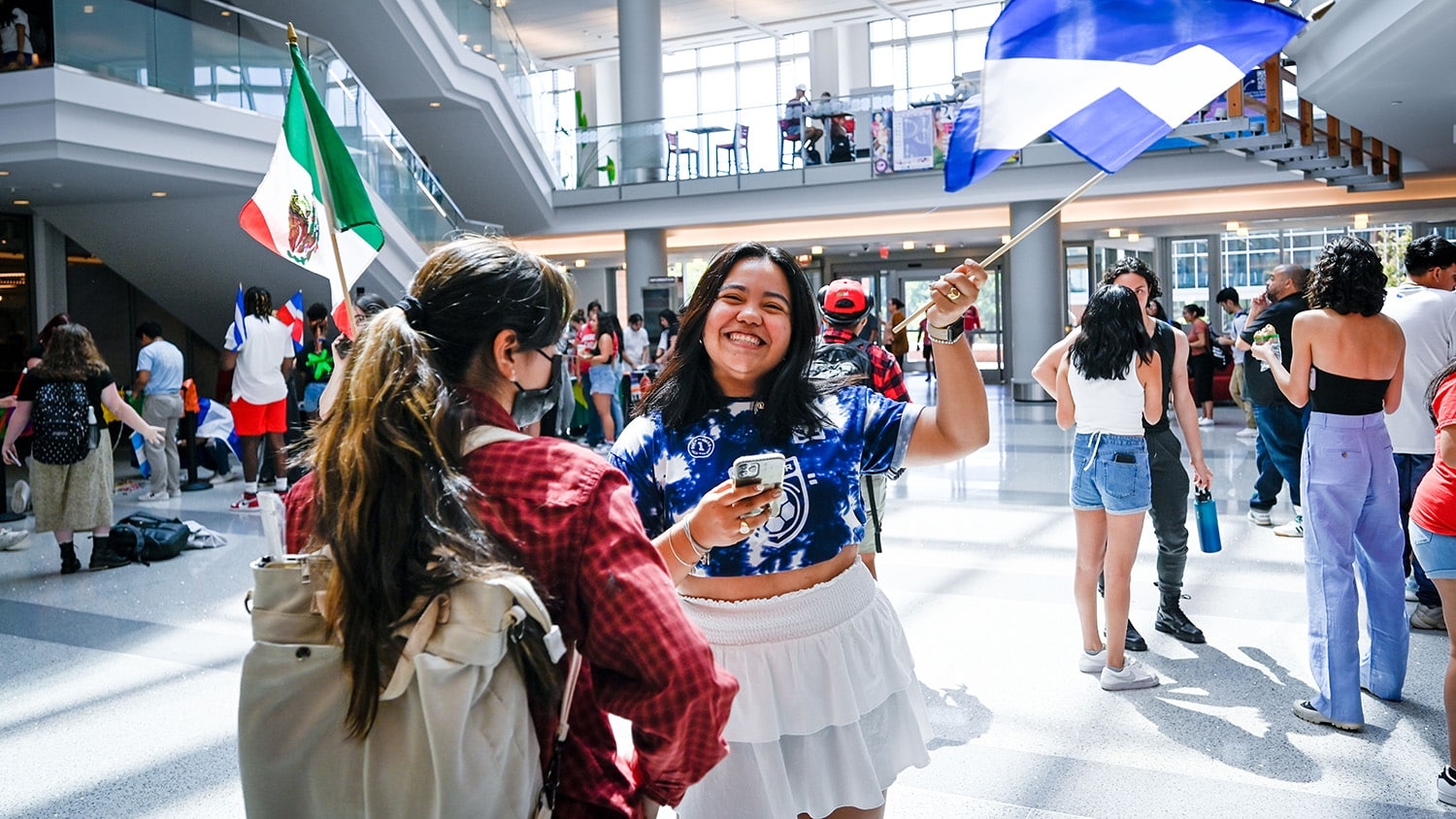 Students hold up flags at the Latinx Heritage Month kickoff event in Talley Student Union.