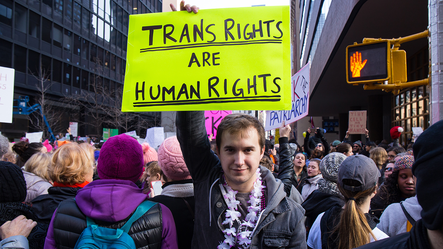 Student holding a sign that reads "Trans Rights are Human Rights"