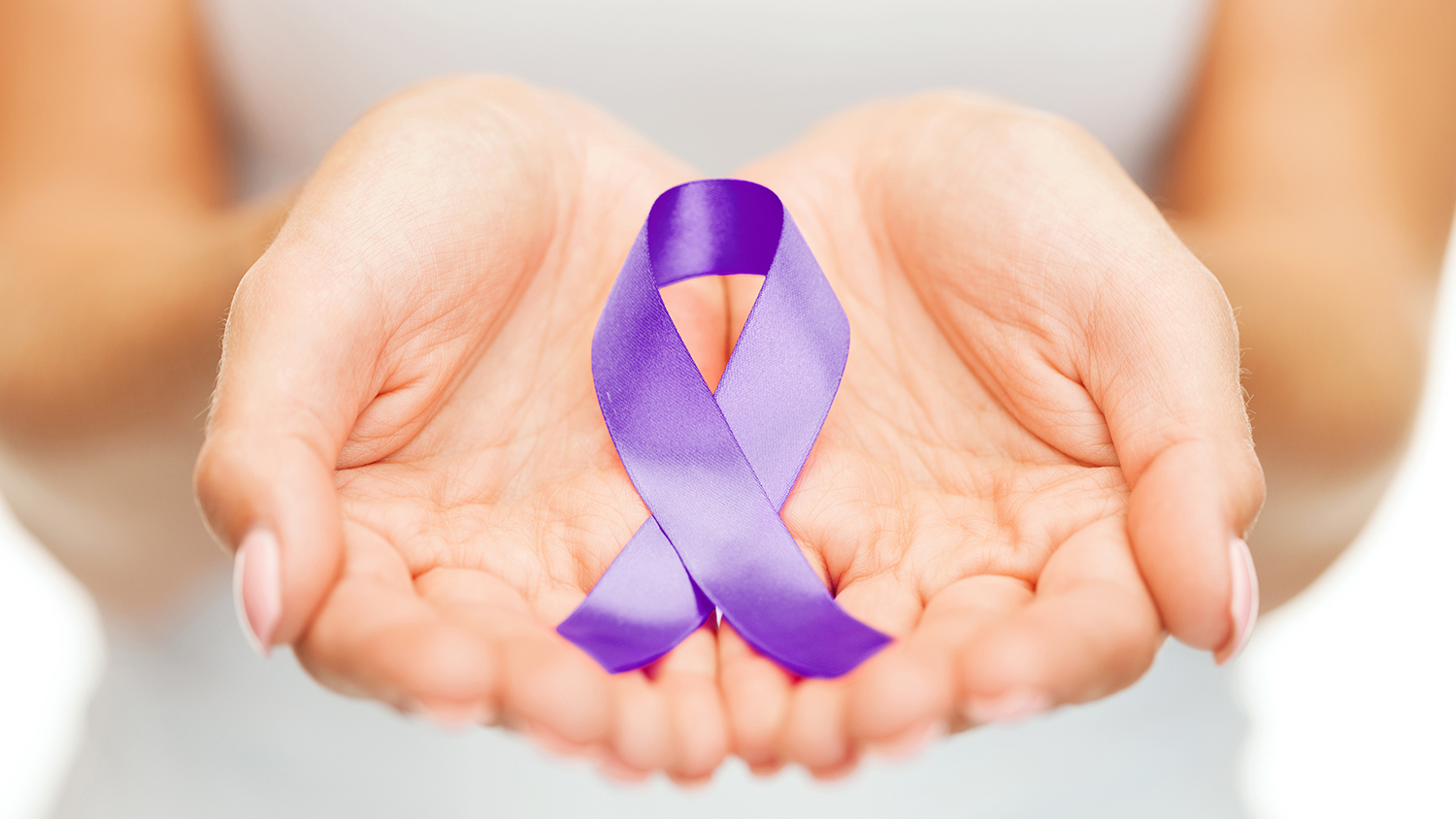 Hands holding purple ribbon for domestic violence awareness